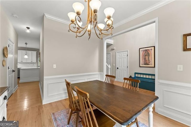 5055 Hamptons Club Dr, Alpharetta, GA 30004 - dining room featuring a chandelier, crown molding, a wainscoted wall, light wood-type flooring, and a decorative wall