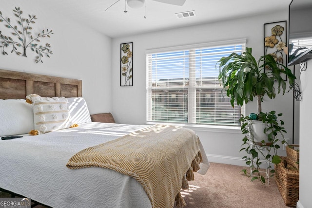 carpeted bedroom with baseboards, ceiling fan, and visible vents