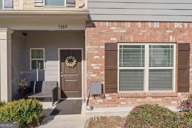 doorway to property featuring brick siding