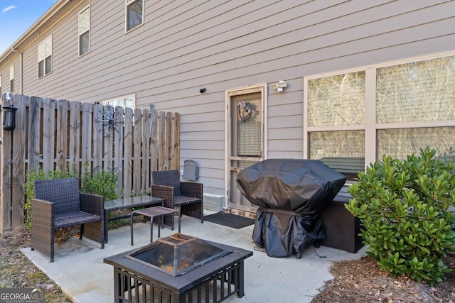 view of patio with a grill, fence, and an outdoor fire pit