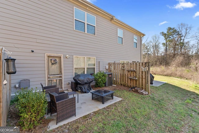 back of property with a fire pit, central AC unit, a yard, and a patio area