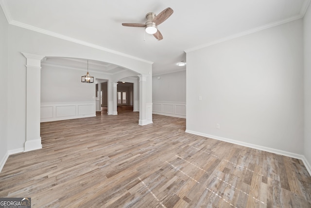 unfurnished living room featuring decorative columns, a decorative wall, arched walkways, light wood-style floors, and a ceiling fan
