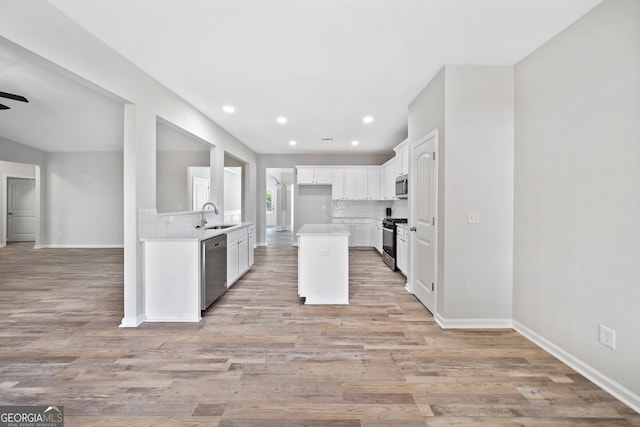 kitchen featuring white cabinetry, light wood-style floors, a sink, and stainless steel appliances