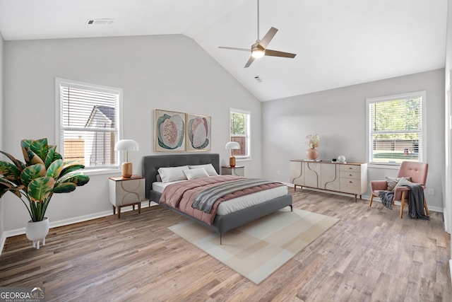 bedroom with baseboards, visible vents, multiple windows, and wood finished floors