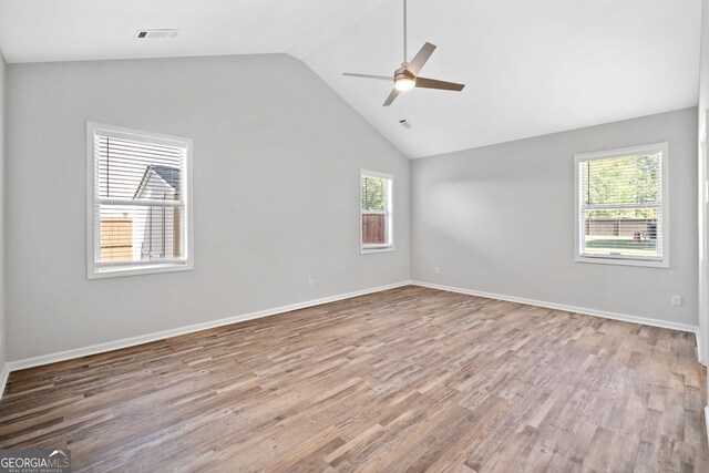 spare room featuring wood finished floors, plenty of natural light, ceiling fan, and visible vents