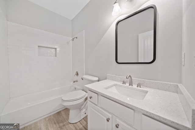 bathroom featuring toilet, vanity, bathtub / shower combination, and wood finished floors