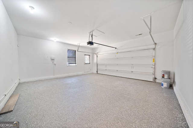 garage with a garage door opener and baseboards