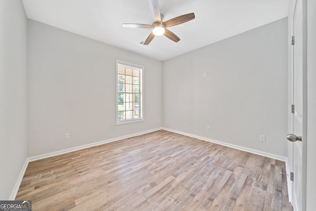 spare room with baseboards, ceiling fan, and light wood-style flooring