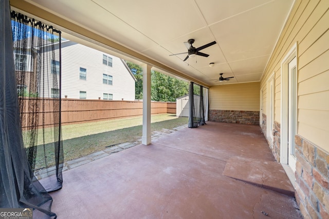 view of patio / terrace featuring an outbuilding, a fenced backyard, a ceiling fan, and a shed