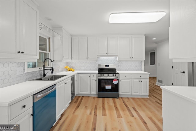 kitchen featuring light wood-style flooring, a sink, tasteful backsplash, stainless steel range with electric stovetop, and dishwasher
