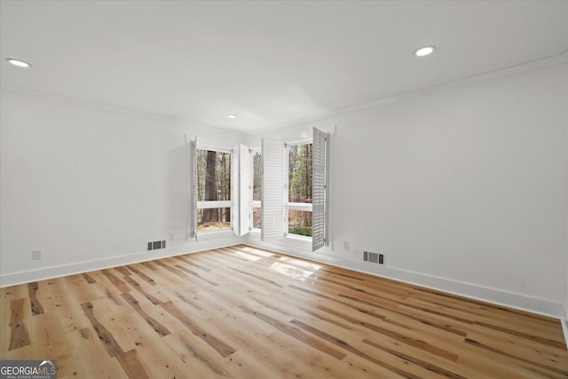 unfurnished room featuring wood finished floors, ornamental molding, visible vents, and recessed lighting