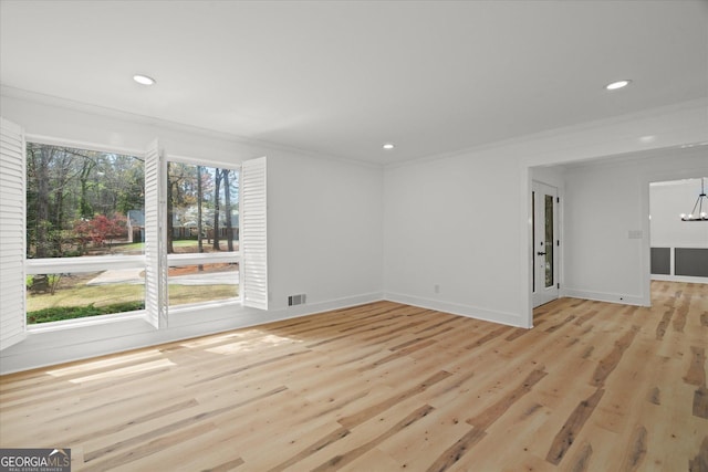 empty room with a chandelier, light wood finished floors, and recessed lighting