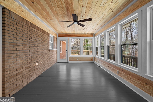 unfurnished sunroom with wood ceiling, brick wall, a wealth of natural light, and hardwood / wood-style floors