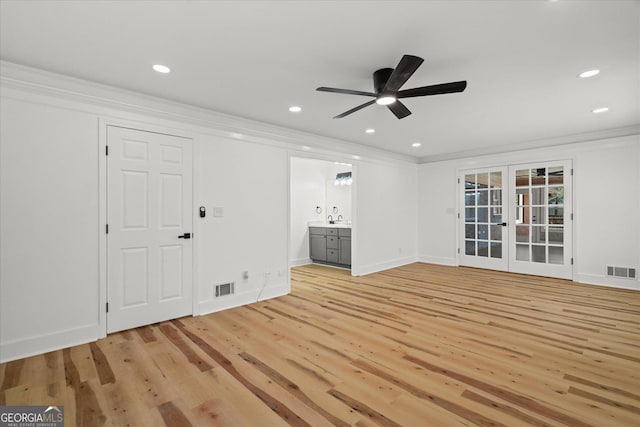 unfurnished living room featuring light wood-type flooring, visible vents, and crown molding