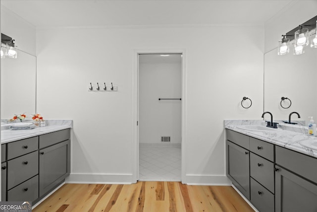 bathroom featuring visible vents, crown molding, and wood finished floors