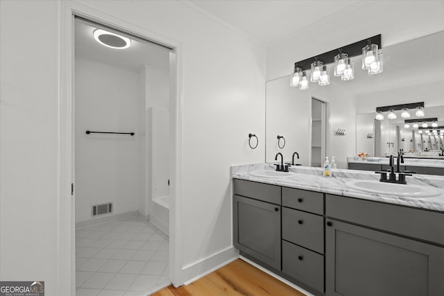 full bath featuring crown molding, double vanity, a sink, and visible vents