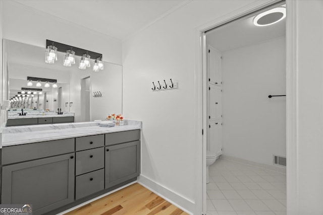 full bathroom featuring vanity, ornamental molding, visible vents, toilet, and baseboards