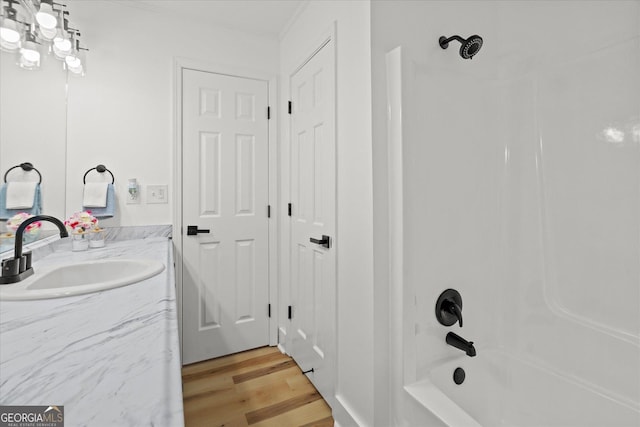 bathroom with vanity, wood finished floors, and tub / shower combination