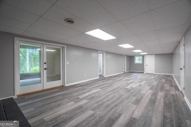 interior space featuring visible vents, a paneled ceiling, french doors, and wood finished floors