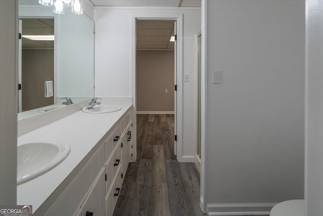 full bath with a stall shower, wood finished floors, and a sink