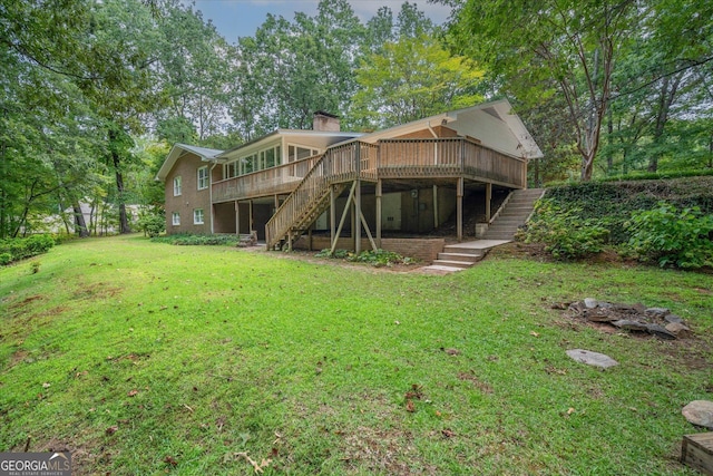 rear view of property featuring a chimney, stairway, a deck, and a yard