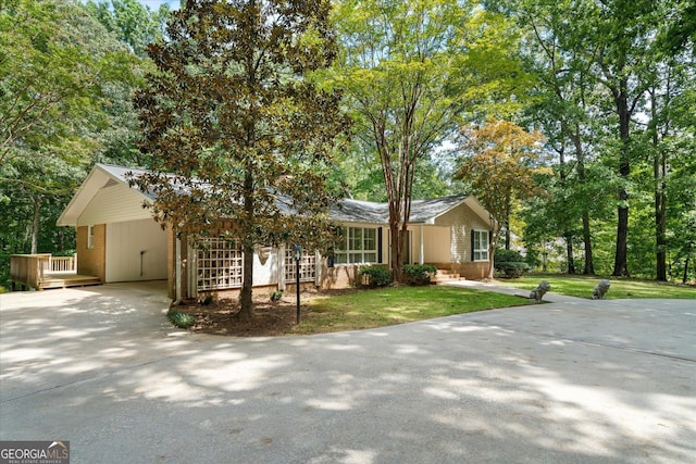 ranch-style home featuring a carport, driveway, a front yard, and brick siding