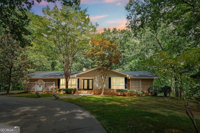 view of front of property featuring french doors, a front lawn, and a chimney