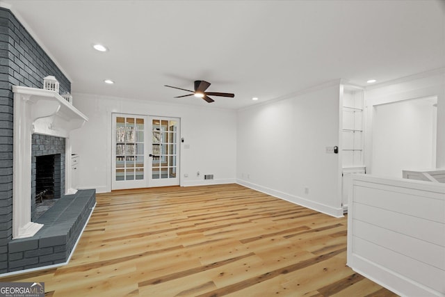 unfurnished living room featuring light wood-style floors, ceiling fan, a fireplace, ornamental molding, and recessed lighting