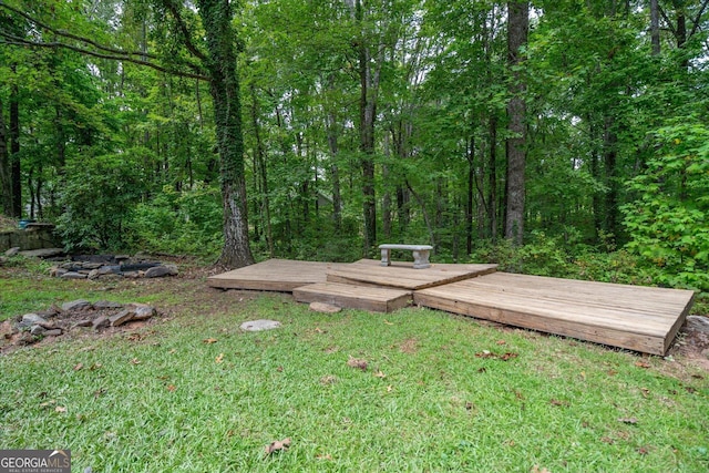 view of yard featuring a view of trees and a deck