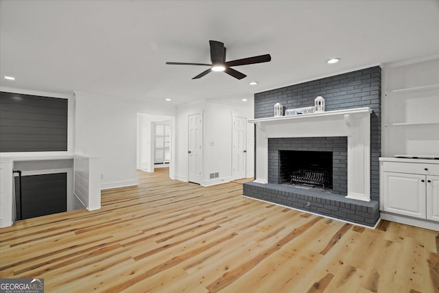 unfurnished living room featuring light wood-style floors, ceiling fan, a fireplace, and recessed lighting