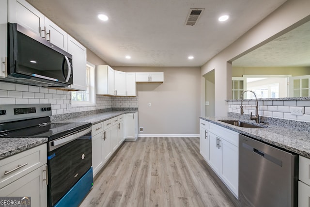 54 Jean Ct, Hiram, GA 30141 - kitchen with a sink, light stone counters, visible vents, white cabinets, and appliances with stainless steel finishes
