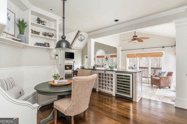 275 Tynebrae Pl, Roswell, GA 30075 - dining room with ornate columns, dark wood finished floors, a fireplace, ceiling fan, and beverage cooler
