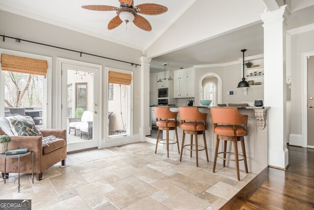 275 Tynebrae Pl, Roswell, GA 30075 - interior space featuring white cabinetry, stainless steel microwave, a breakfast bar area, and decorative columns