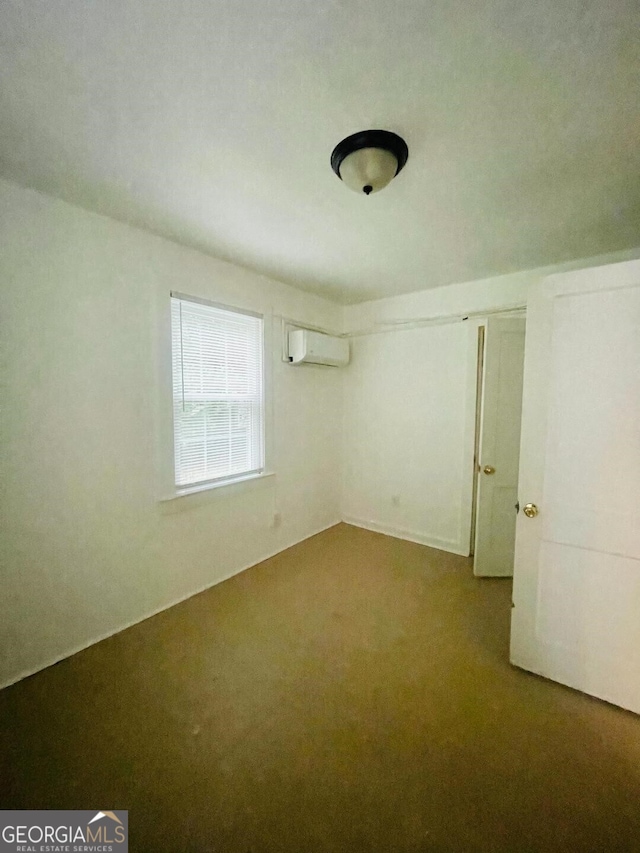 107 Little St SE, Milledgeville, GA 31061 - unfurnished bedroom with carpet floors and a wall mounted air conditioner