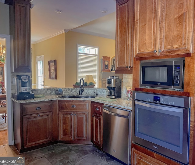 198 Oakdale Rd SE, Cairo, GA 39828 - kitchen featuring crown molding, a sink, light stone counters, a peninsula, and appliances with stainless steel finishes