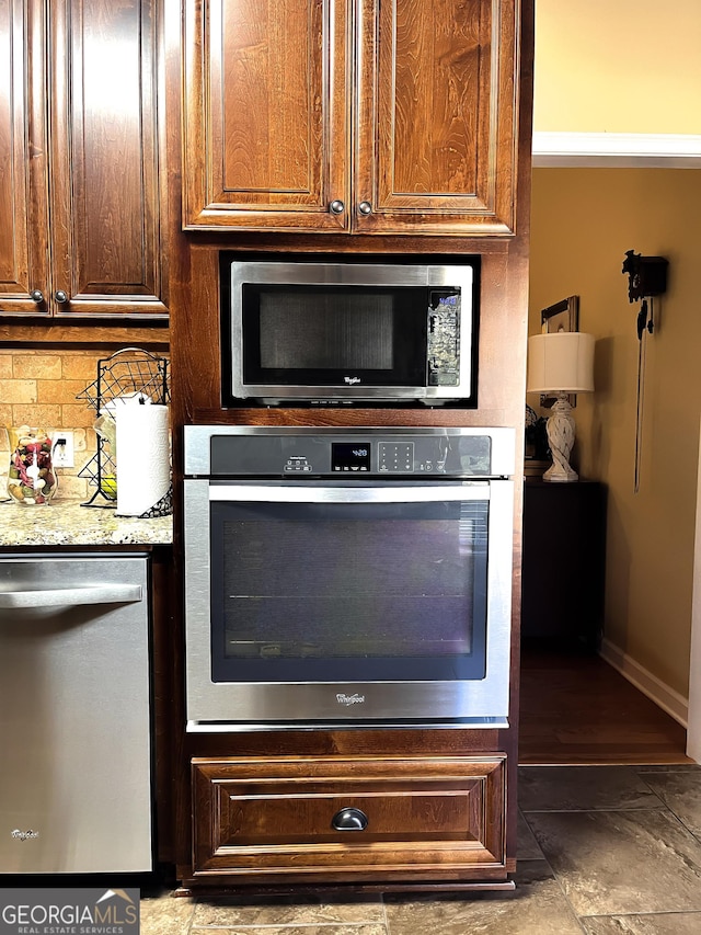 198 Oakdale Rd SE, Cairo, GA 39828 - details with baseboards, light stone counters, backsplash, and appliances with stainless steel finishes