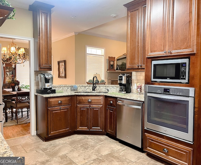198 Oakdale Rd SE, Cairo, GA 39828 - kitchen featuring crown molding, a sink, appliances with stainless steel finishes, decorative backsplash, and an inviting chandelier