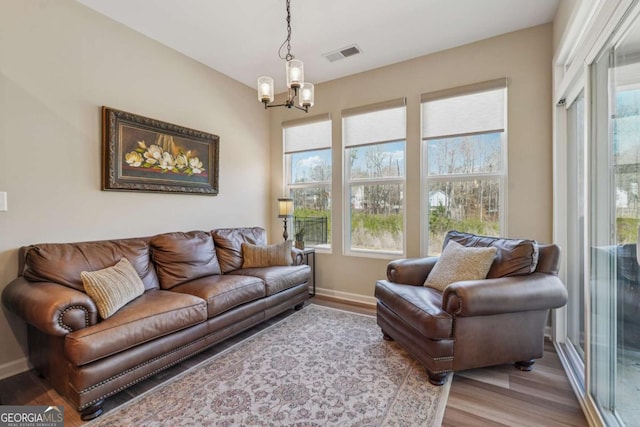67 Narrowleaf Ln, Dallas, GA 30157 - living area featuring an inviting chandelier, wood finished floors, baseboards, and visible vents