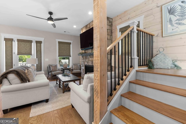 24 Harrison Ln, Blue Ridge, GA 30513 - living room featuring ceiling fan, a fireplace, wood finished floors, stairs, and wooden walls