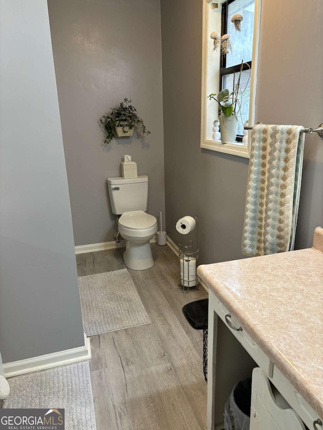 575 Lake Laurel Rd, Milledgeville, GA 31061 - bathroom featuring toilet, baseboards, and wood finished floors