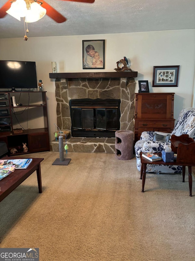 575 Lake Laurel Rd, Milledgeville, GA 31061 - living area featuring a ceiling fan, a stone fireplace, a textured ceiling, and carpet