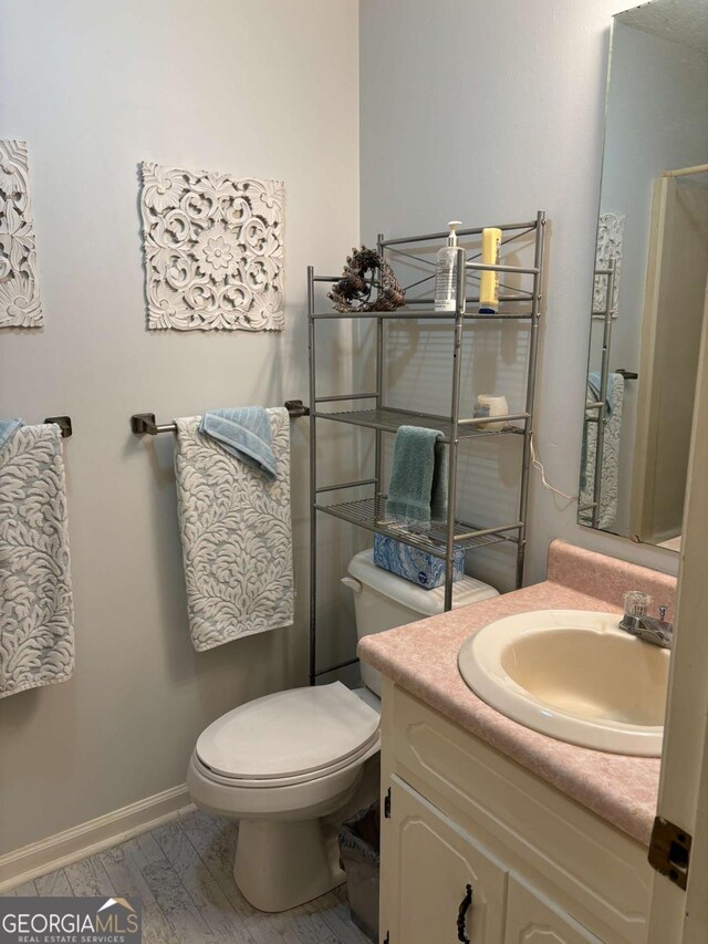 575 Lake Laurel Rd, Milledgeville, GA 31061 - bathroom featuring toilet, baseboards, and vanity