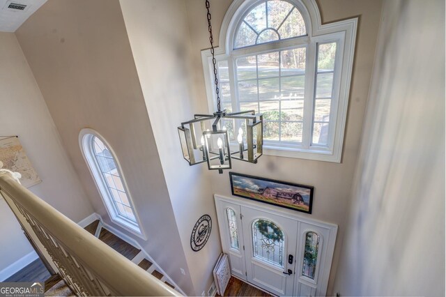 667 Cardinal Dr, Monticello, GA 31064 - entrance foyer with dark wood finished floors, baseboards, visible vents, and an inviting chandelier