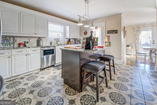 667 Cardinal Dr, Monticello, GA 31064 - kitchen featuring stainless steel dishwasher, white cabinets, a center island, and a kitchen bar