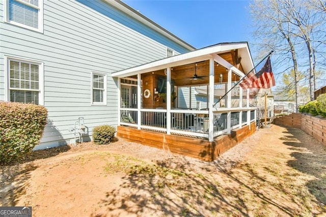 5753 Porch Swing Pl, Hoschton, GA 30548 - rear view of property with a sunroom, a ceiling fan, and a fenced backyard