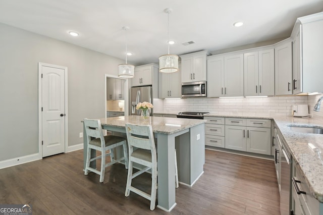 557 Winder Trl, Canton, GA 30114 - kitchen featuring stainless steel appliances, a kitchen island, decorative backsplash, light stone counters, and dark wood-style floors