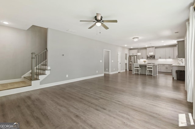 557 Winder Trl, Canton, GA 30114 - unfurnished living room with a ceiling fan, recessed lighting, wood finished floors, and stairs