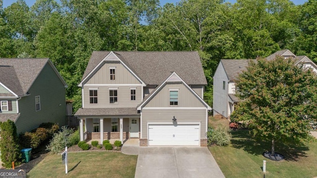 557 Winder Trl, Canton, GA 30114 - craftsman-style home with covered porch, board and batten siding, a front lawn, a shingled roof, and driveway