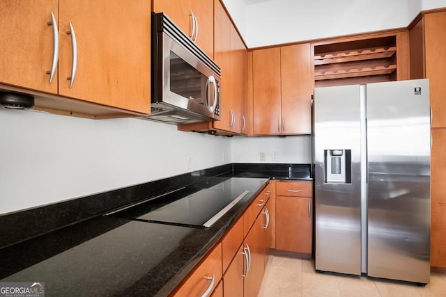 kitchen featuring brown cabinetry, open shelves, dark stone counters, and appliances with stainless steel finishes