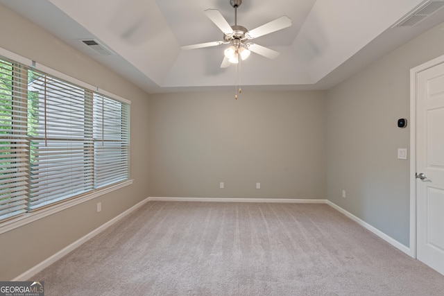 145 Sunset Ln, Woodstock, GA 30189 - spare room featuring a raised ceiling, light colored carpet, ceiling fan, and baseboards